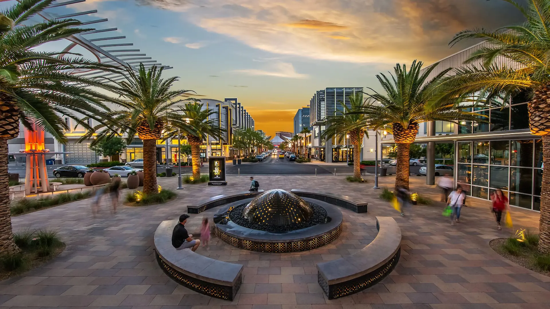 Downtown Summerlin – A modern shopping and entertainment district with palm trees, fountains, and a sunset in the background.