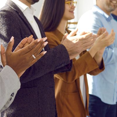 Diverse audience applauding at a public conference. Multiracial group of happy people smiling and clapping hands to express respect and gratitude to an interesting business lecturer. Header background