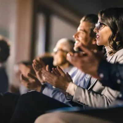 A group of people clapping, celebrating together in a cheerful and supportive atmosphere.