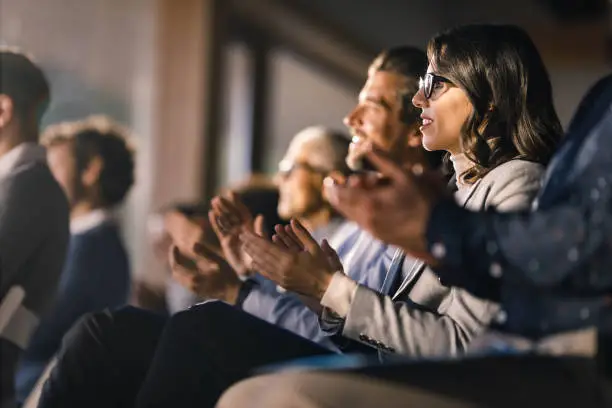 A group of people clapping, celebrating together in a cheerful and supportive atmosphere.